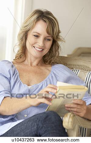 Mid age woman reading a book View Large Photo Image Stock Image - Mid age woman reading a book. Fotosearch