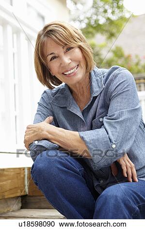 Mid age woman relaxing in garden View Large Photo Image Stock Image - Mid age woman relaxing in garden. Fotosearch