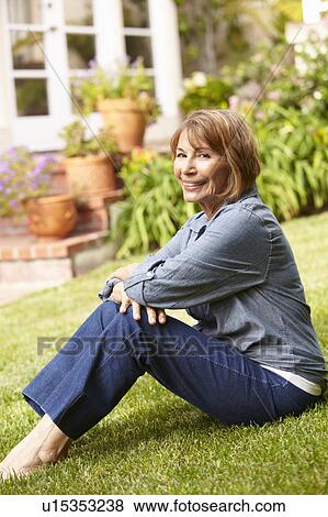 Mid age woman relaxing in garden View Large Photo Image Stock Photo - Mid age woman relaxing in garden. Fotosearch