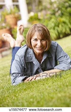 Stock Photo - Mid age woman relaxing in garden. Fotosearch