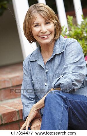 Stock Photo - Mid age woman relaxing in garden. Fotosearch