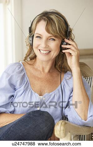 Mid age woman wearing headphones View Large Photo Image Stock Photo - Mid age woman wearing headphones. Fotosearch