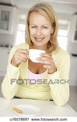 Mid age woman with coffee at home View Large Photo Image Stock Photo - Mid age woman with coffee at home. Fotosearch