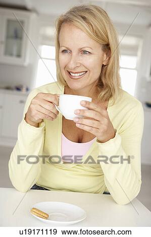 Mid age woman with coffee at home View Large Photo Image Stock Photo - Mid age woman with coffee at home. Fotosearch