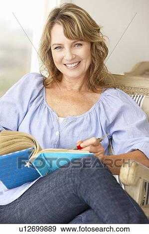 Mid age woman writing in notebook View Large Photo Image Stock Photo - Mid age woman writing in notebook. Fotosearch
