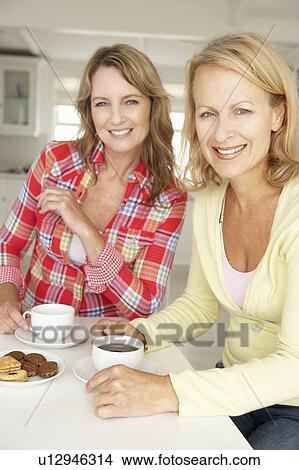 Mid age women chatting over coffee at home View Large Photo Image Picture - Mid age women chatting over coffee at home. Fotosearch
