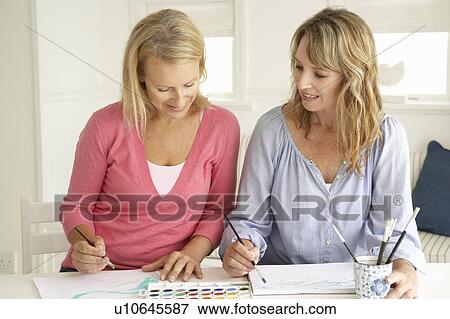 Stock Photo - Mid age women painting with watercolors. Fotosearch