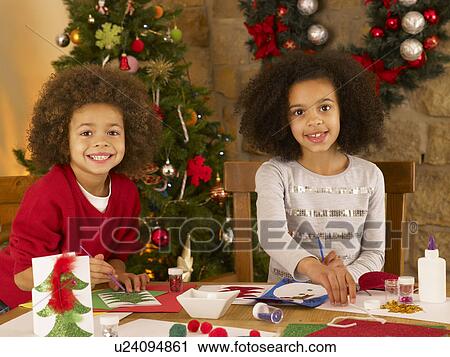 Stock Image - Mixed race children making Christmas cards. Fotosearch