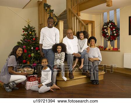 Mixed race family with Christmas tree and gifts View Large Photo Image Picture - Mixed race family with Christmas tree and gifts. Fotosearch