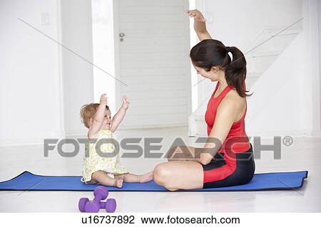 Stock Image - Mother and baby doing yoga. Fotosearch