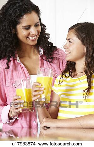 Picture - Mother and daughter drinking orange juice. Fotosearch