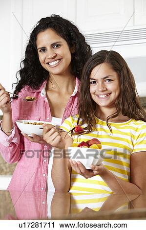 Mother and daughter eating cereal and fruit View Large Photo Image Stock Image - Mother and daughter eating cereal and fruit. Fotosearch