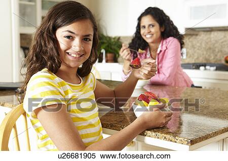 Stock Photography - Mother and daughter eating cereal and fruit. Fotosearch