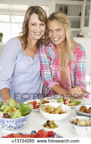 Stock Photography - Mother and teenage daughter enjoying meal at home. Fotosearch