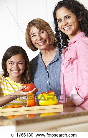 Stock Image - Mother, daughter and grandmother cooking. Fotosearch