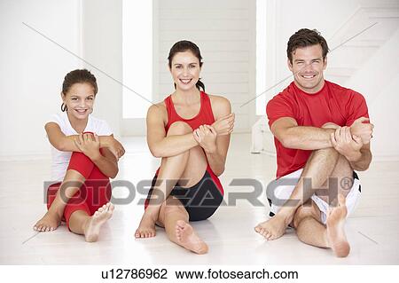 Stock Image - Mother, father and daughter doing yoga. Fotosearch
