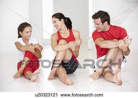 Stock Image - Mother, father and daughter doing yoga. Fotosearch