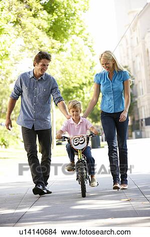 Parents with boy on bike View Large Photo Image Picture - Parents with boy on bike. Fotosearch
