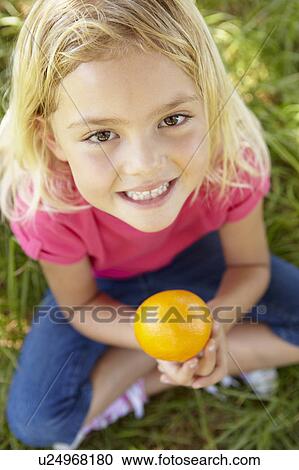 Portrait of happy girl with orange View Large Photo Image Stock Image - Portrait of happy girl with orange. Fotosearch