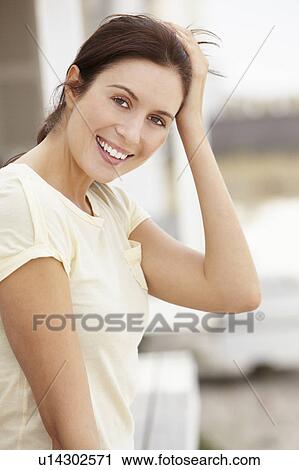 Stock Image - Portrait woman sitting outdoors. Fotosearch