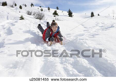 Stock Photography - Pre-teen Boy On A Sled In The Snow. Fotosearch