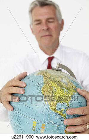 Stock Image - Senior businessman holding globe. Fotosearch