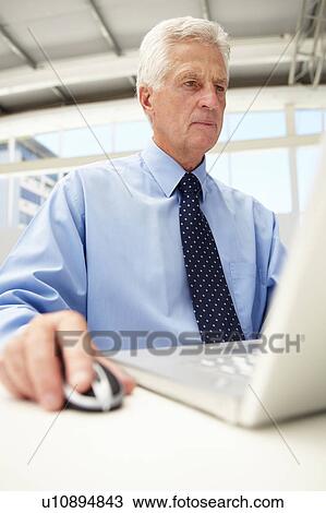 Stock Image - Senior businessman using laptop. Fotosearch