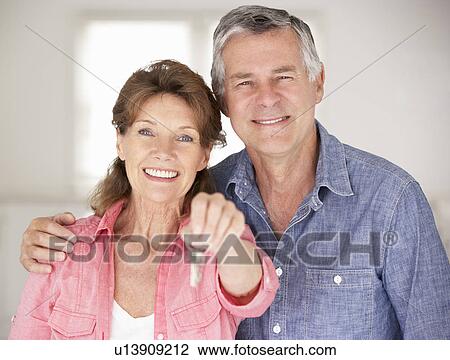 Stock Image - Senior couple moving into new home. Fotosearch
