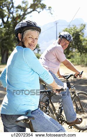Picture - Senior couple on country bike ride. Fotosearch