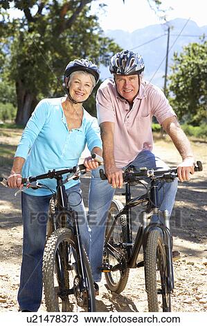 Stock Image - Senior couple on country bike ride. Fotosearch