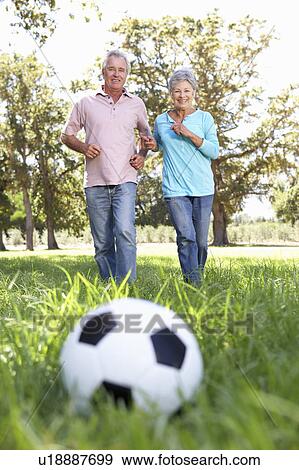 Stock Photo - Senior couple playing football. Fotosearch