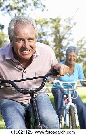Senior couple playing on children's bikes View Large Photo Image Stock Photography - Senior couple playing on children's bikes. Fotosearch