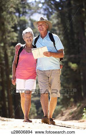 Picture - Senior couple reading map on country walk. Fotosearch