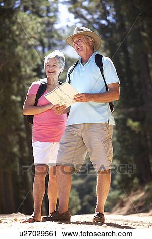 Senior couple reading map on country walk View Large Photo Image Stock Image - Senior couple reading map on country walk. Fotosearch