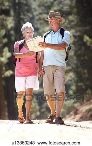 Stock Photo - Senior couple reading map on country walk. Fotosearch