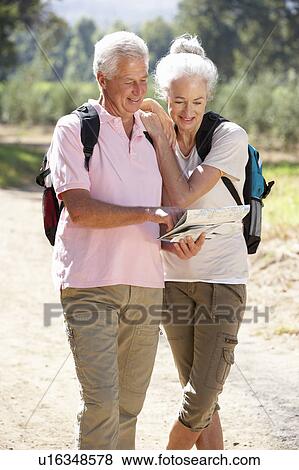 Senior couple reading map on country walk View Large Photo Image Stock Photo - Senior couple reading map on country walk. Fotosearch
