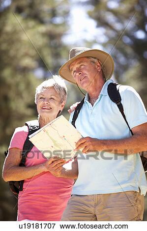 Stock Photo - Senior couple reading map on country walk. Fotosearch