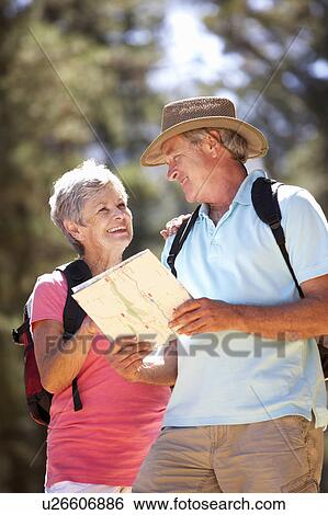 Stock Photograph - Senior couple reading map on country walk. Fotosearch