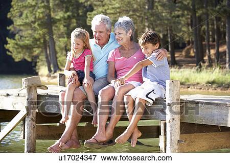 Senior couple sitting by lake with grandchildren View Large Photo Image Stock Photo - Senior couple sitting by lake with grandchildren. Fotosearch
