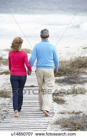 Stock Photo - Senior couple walking by the sea. Fotosearch