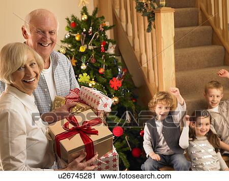 Senior couple with grandchildren at Christmas View Large Photo Image Stock Image - Senior couple with grandchildren at Christmas. Fotosearch