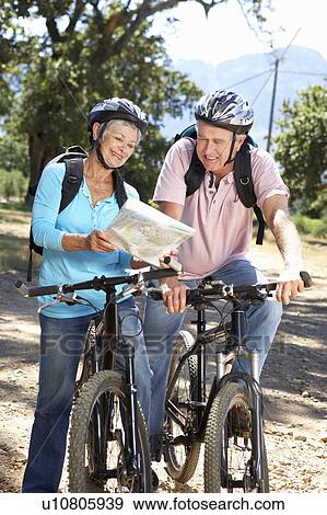 Senior couple with map on country bike ride View Large Photo Image Stock Photo - Senior couple with map on country bike ride. Fotosearch