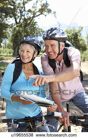 Stock Photo - Senior couple with map on country bike ride. Fotosearch