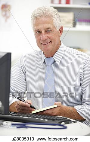 Senior doctor at desk View Large Photo Image Stock Image - Senior doctor at desk. Fotosearch