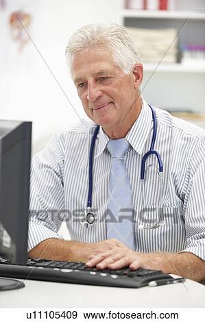 Stock Photo - Senior doctor at desk. Fotosearch