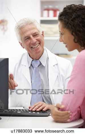 Stock Image - Senior doctor with female patient. Fotosearch