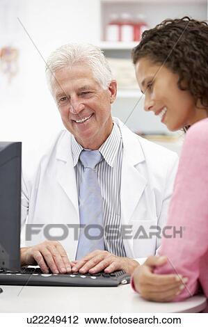 Stock Image - Senior doctor with female patient. Fotosearch