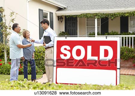 Stock Photo - Senior Hispanic couple buying new home. Fotosearch