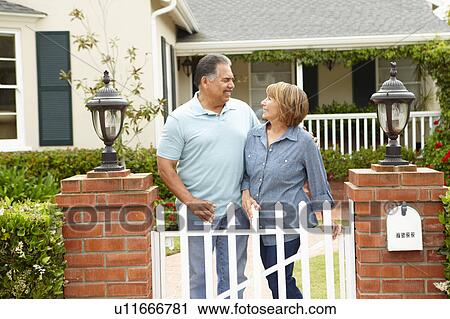 Stock Image - Senior Hispanic couple outside home. Fotosearch