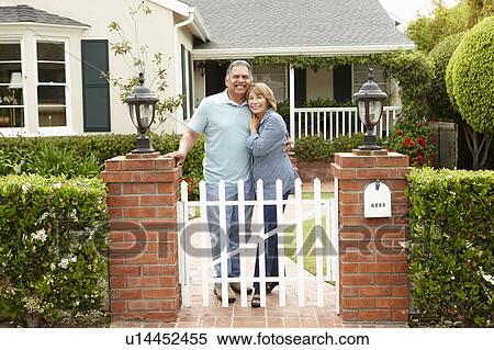 Stock Photography - Senior Hispanic couple outside home. Fotosearch